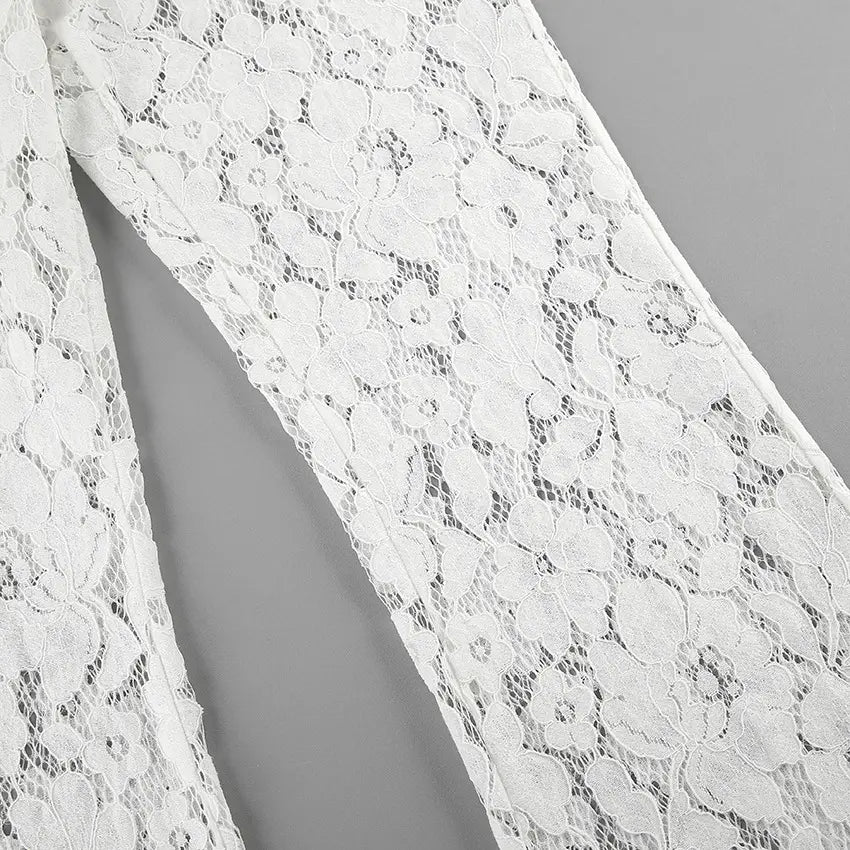 Close-up view of Kaelia white lace flared trousers showcasing intricate floral jacquard texture and sheer fabric construction. The wide leg silhouette is partially visible.