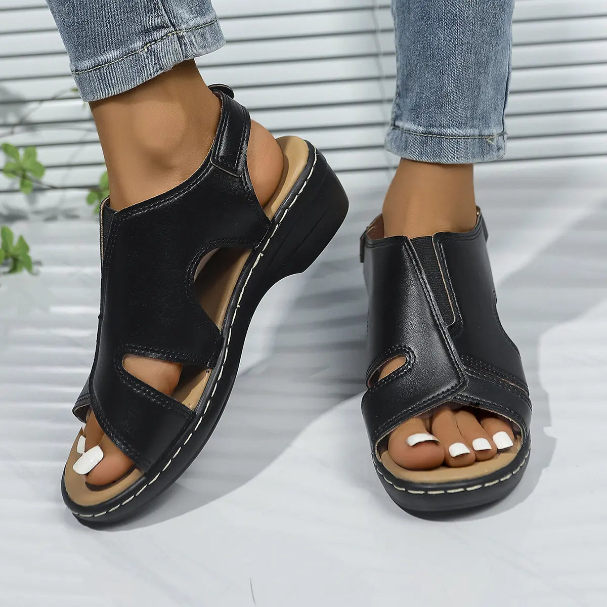 Black Kaelin platform wedge sandals for women, featuring a peep-toe design, smooth faux leather, white contrast stitching, and an adjustable ankle strap.