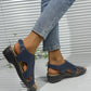 Women's navy blue Kaelin platform wedge sandals with peep-toe, cut-out vamp strap, and adjustable ankle strap, shown worn with jeans.