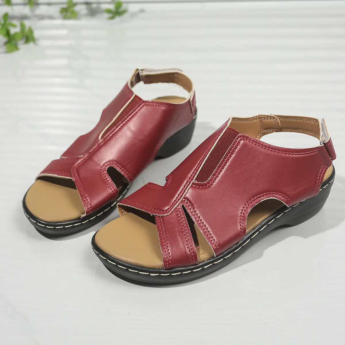 Kaelin ruby red faux leather wedge sandals featuring a peep-toe design, elastic gore, and adjustable ankle strap, shown from a three-quarter view on a white background.