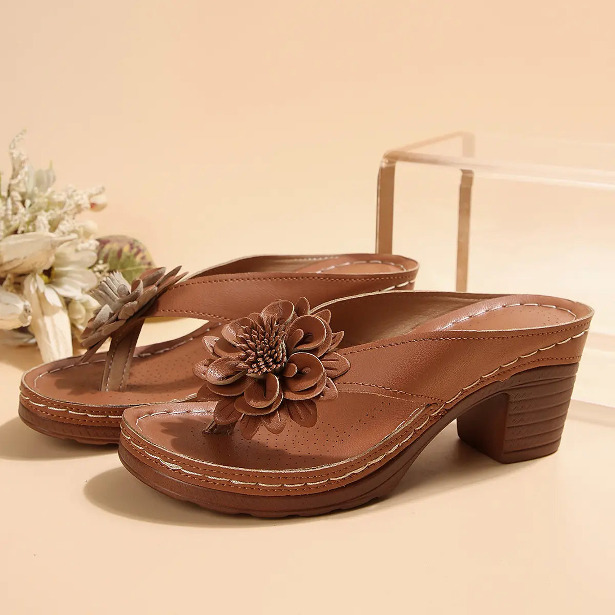 Brown Kaelis women's platform sandals featuring a large 3D floral embellishment on the wide strap, stacked block heel, and detailed layered sole.