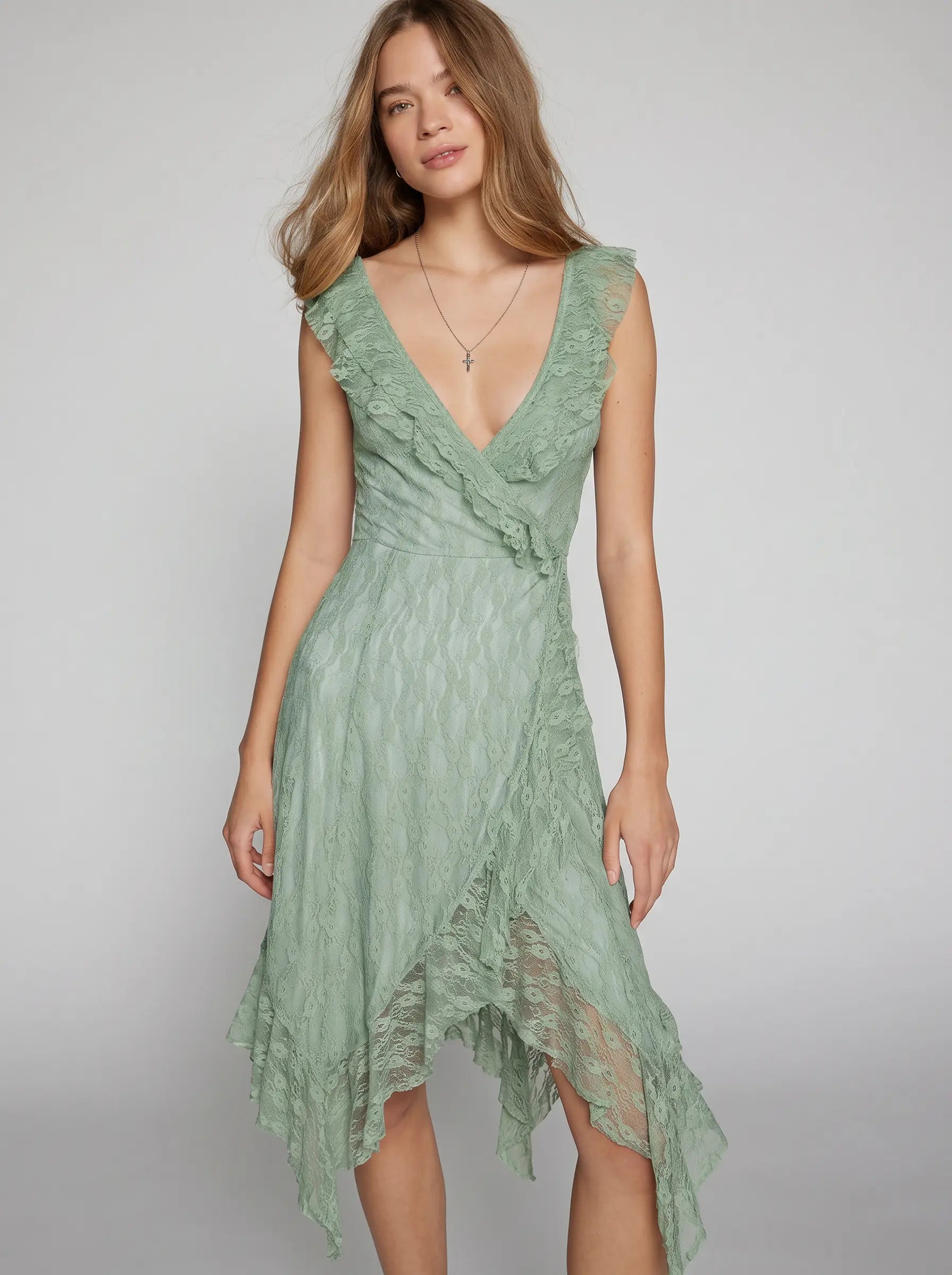 Misty Sage Green Kaelis romantic boho chic midi dress featuring a V-neck with cascading ruffles and an asymmetrical tiered ruffle hem, shown on a model.