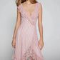Kaelis romantic midi boho chic lace V-neck dress in soft pink, showcasing its flowing asymmetrical tiered ruffle hem and sleeveless design worn by a model.
