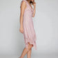 Woman in a flowing pink Kaelis lace midi dress featuring a V-neck with cascading ruffles and an asymmetrical tiered ruffle hem. This bohemian-chic style is shown in profile.