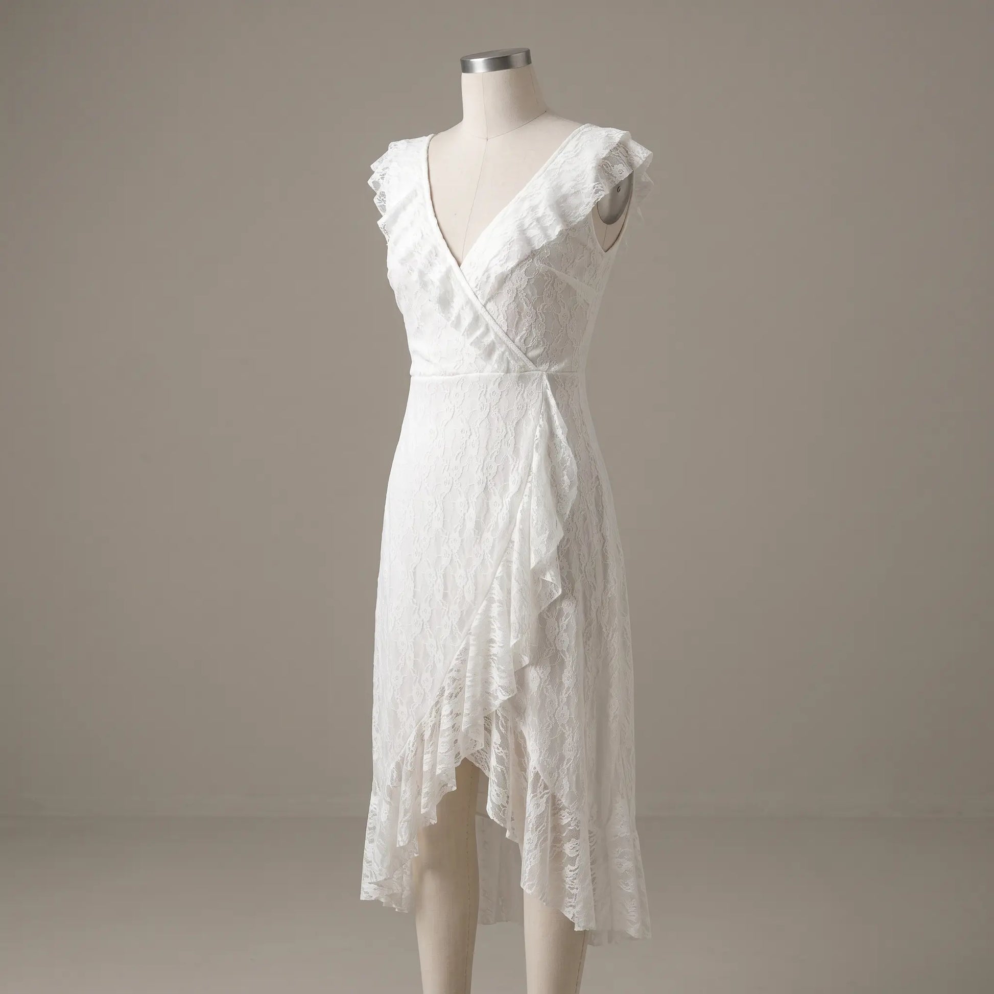 Kaelis white lace V-neck midi dress featuring cascading ruffled V-neckline, sleeveless design, and an asymmetrical tiered ruffle hem, displayed on a mannequin.