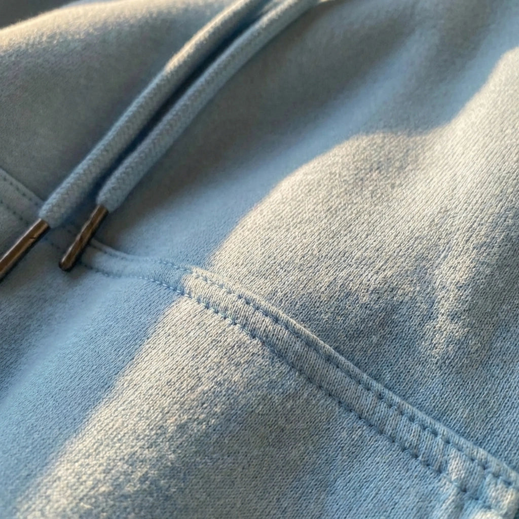 Kaelo premium cropped hoodie in soft-touch fleece — close-up detail showing fabric texture, reinforced stitching, and metal-tipped drawstrings.