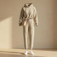Kaelo women's cropped hoodie and jogger set in sand beige fleece, front view showing the adjustable toggle waist and matching crossbody bag styling.