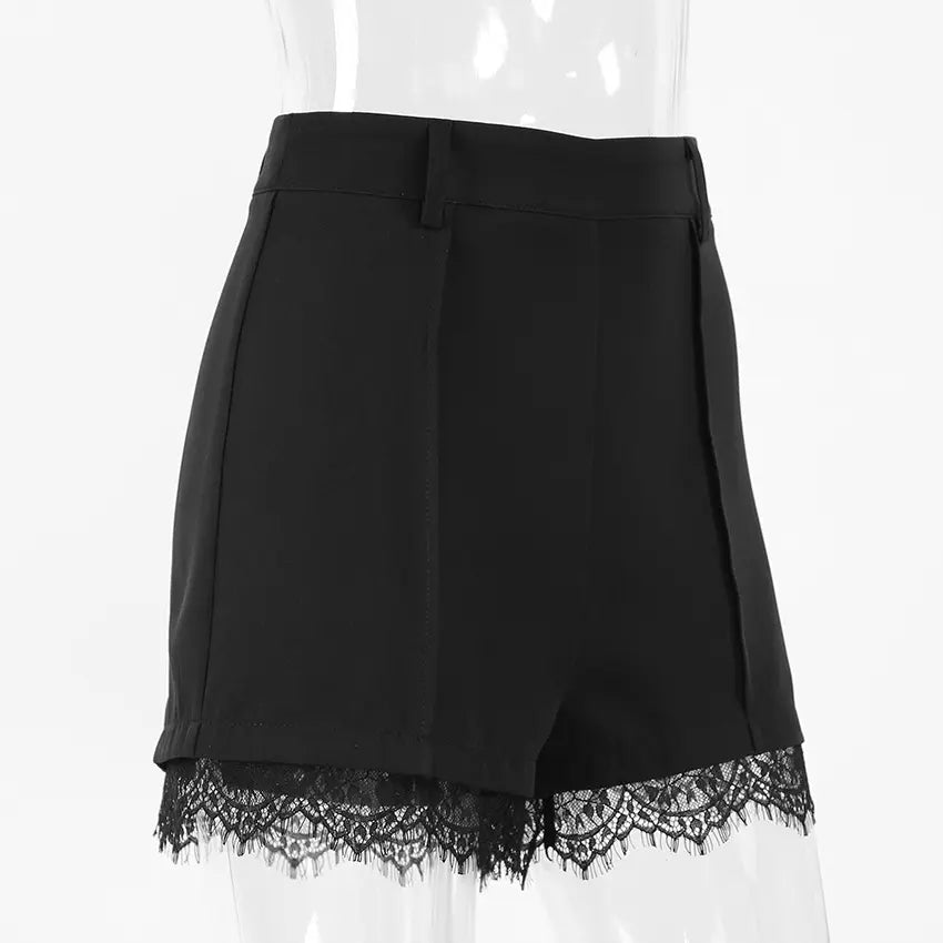 Black high-waisted A-line shorts with delicate floral lace trim on the hem, featuring front pleats and a tailored silhouette, shown from a three-quarter side view.