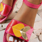 Close-up of a Kaelos women's flat sandal in bright pink, featuring a strap adorned with multi-colored heart appliques in red, yellow, gold, and pink. The sandal has a black elasticated ankle strap with white contrast stitching.
