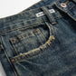 Kaelos high waisted jeans in vintage wash denim — close-up detail showing the distressed pocket edge, copper rivets, and waistband label.