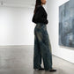 Kaelos high-waisted wide-leg jeans in vintage wash denim, side profile view showing the floor-grazing cut and distressed back pocket detail.