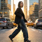 Kaelos high waisted wide leg jeans in vintage wash dark blue denim, styled with a black blazer in a city setting — side view showing the relaxed fit and movement.