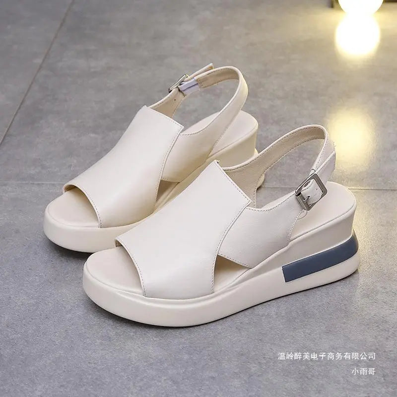 Creamy off-white Kaelos wedge sandals with crossover peep-toe, slingback buckle strap, and a light grey stripe accent on the wedge.