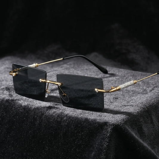 Close-up view of Kaelos luxury rimless sunglasses temple, showcasing sparkling micro-crystal embellishments on the gold-tone metal and black acetate ear tip.
