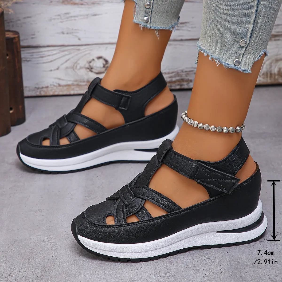 Black Kaelum platform wedge sandals with cut-out straps worn by a model, showcasing the side view and measurement details.