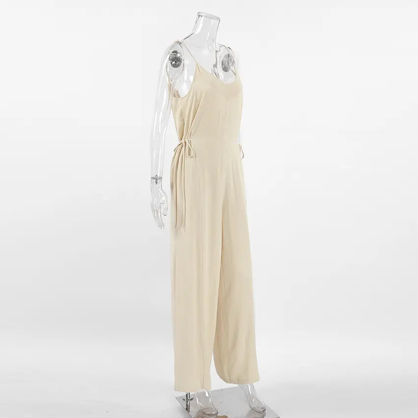 Side view of a Kaelum oatmeal beige linen blend wide leg jumpsuit with V-neck and spaghetti straps, displayed on a mannequin.