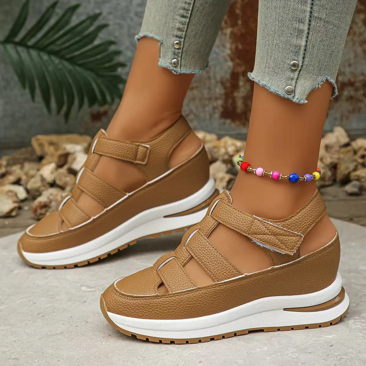 Women's tan Kaelum platform wedge sandals shown on a model's feet with a beaded anklet, featuring a closed round toe and three cut-out straps with hook-and-loop closures.