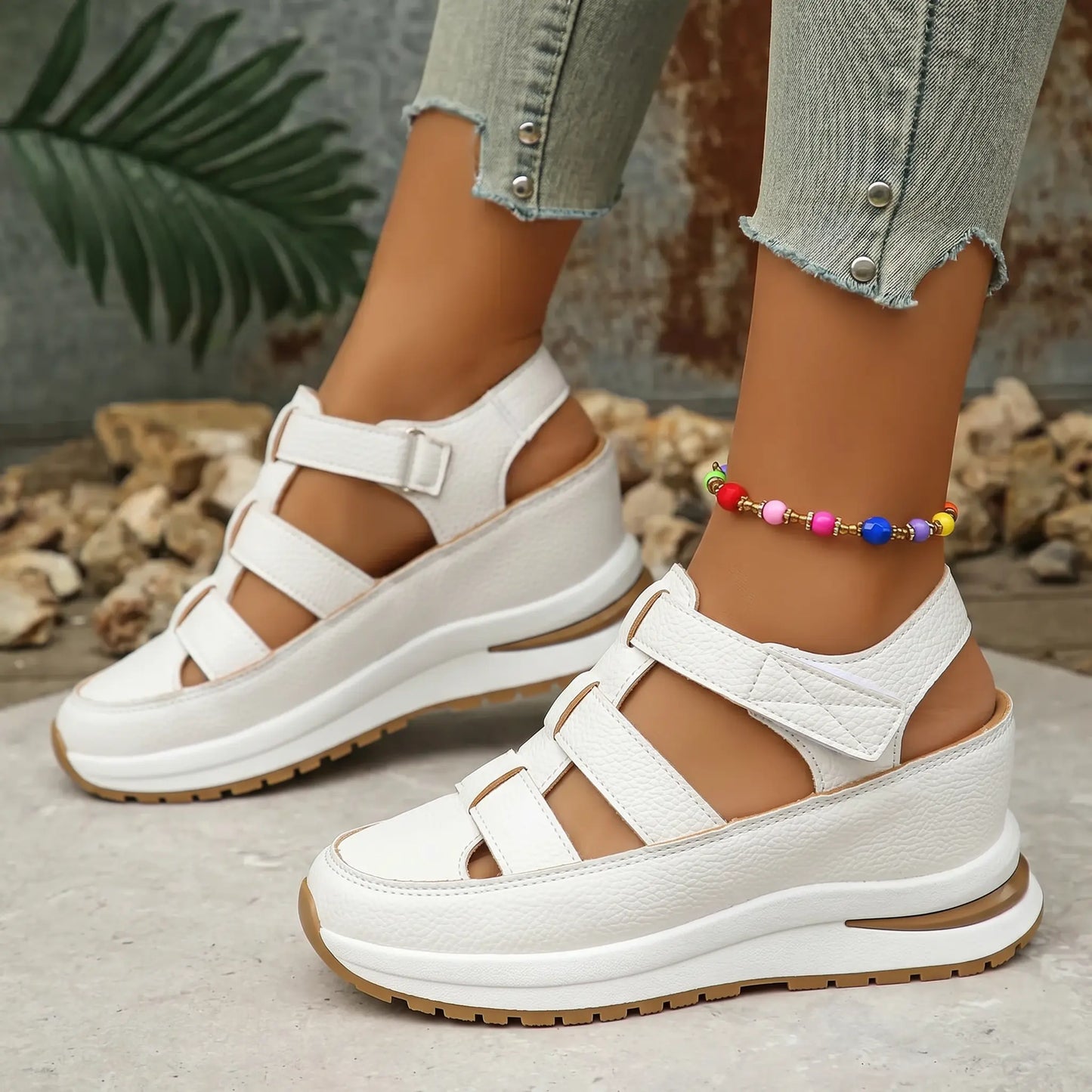 Women's Kaelum pure white platform wedge sandals featuring a closed round toe, three horizontal cut-out straps with hook-and-loop fasteners, and a layered white and black sole, styled on a person's feet with light denim.