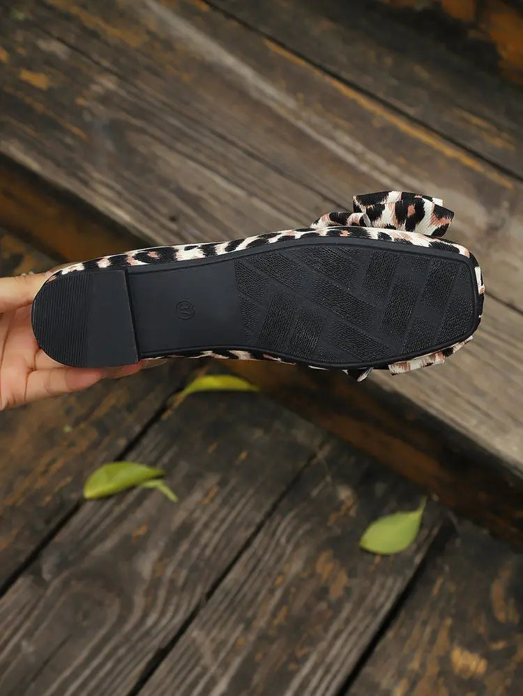 Close-up view of the bottom sole of Kaeluxe leopard print ballet flats, showcasing the textured rubber outsole and decorative bow detail.