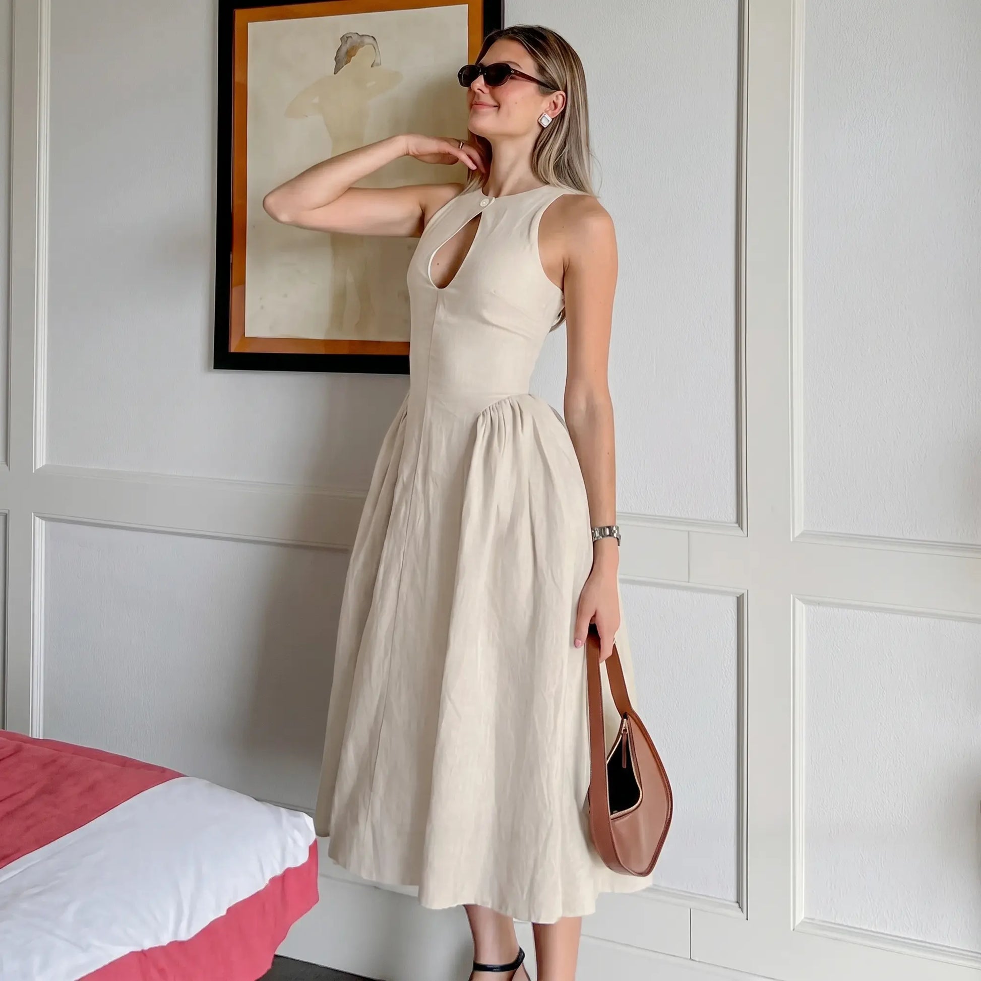 Elegant Kalira linen blend midi dress in natural beige, featuring a sleeveless design, keyhole neckline with button detail, and a flattering gathered A-line skirt worn by a model.