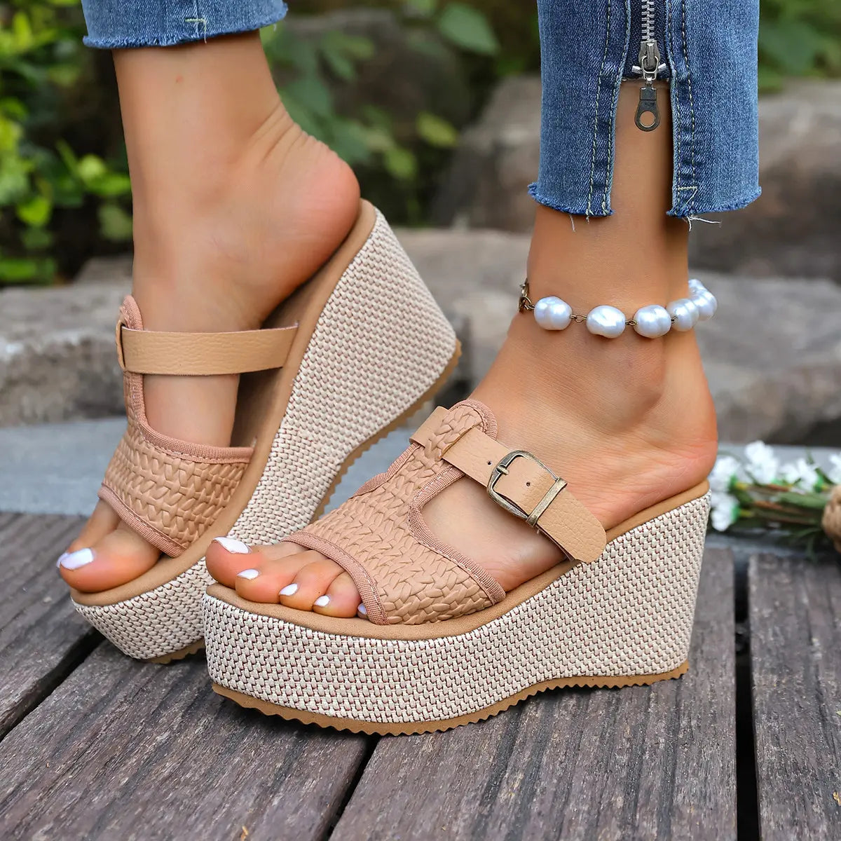 Kalix woven platform espadrille sandals in tan, styled on a model's feet with flared denim jeans and a pearl anklet, showcasing the open-toe T-strap design and espadrille wedge.