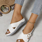 Kalyx white faux leather wedge sandals with elegant criss-cross straps and a gold buckle, shown on a model's feet in a bohemian summer lifestyle scene.