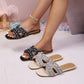 Kezia embellished flat sandals in black and ivory pearl, featuring pearl and rhinestone detailing on a wide strap and square toe, shown on a model's foot and a second pair on the floor.