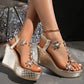 Khosha gold sparkling wedge sandals with crystal floral embellishments and clear transparent straps, worn on feet with an ankle chain, showcasing the textured metallic heel and platform sole.