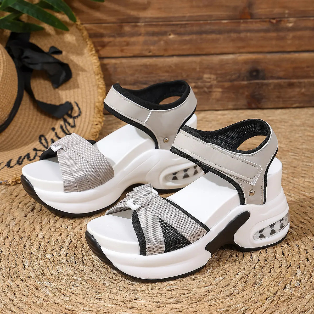 Women's Khyra black and grey woven textile platform sandals with adjustable hook-and-loop straps, white layered EVA midsole, black outsole, and visible air cushion heel, styled with a straw hat.