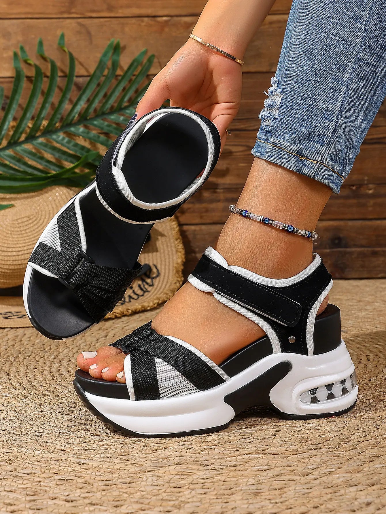 Women's black and grey woven textile platform sandals featuring a bow detail, adjustable hook-and-loop ankle strap, white layered EVA midsole, black rubber outsole, and a transparent air cushion heel.