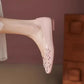 Blush Rose Khyzet square toe flats featuring delicate tonal floral appliques with pearl centers. The elegant vegan leather shoe is worn on a foot, viewed three-quarter.