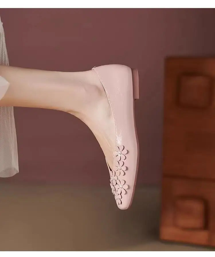 Blush Rose Khyzet square toe flats featuring delicate tonal floral appliques with pearl centers. The elegant vegan leather shoe is worn on a foot, viewed three-quarter.