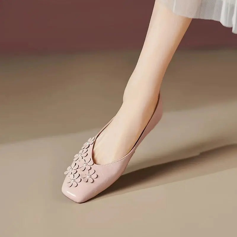 Blush Rose vegan leather square toe flats by Khyzet, adorned with delicate tonal floral appliques and pearl centers, worn on a foot.