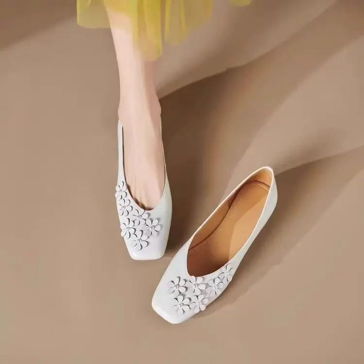 Exquisite Ivory Pearl square toe flats with tonal 3D floral appliques, one worn on a foot and the other displayed beside it, showcasing their elegant design.