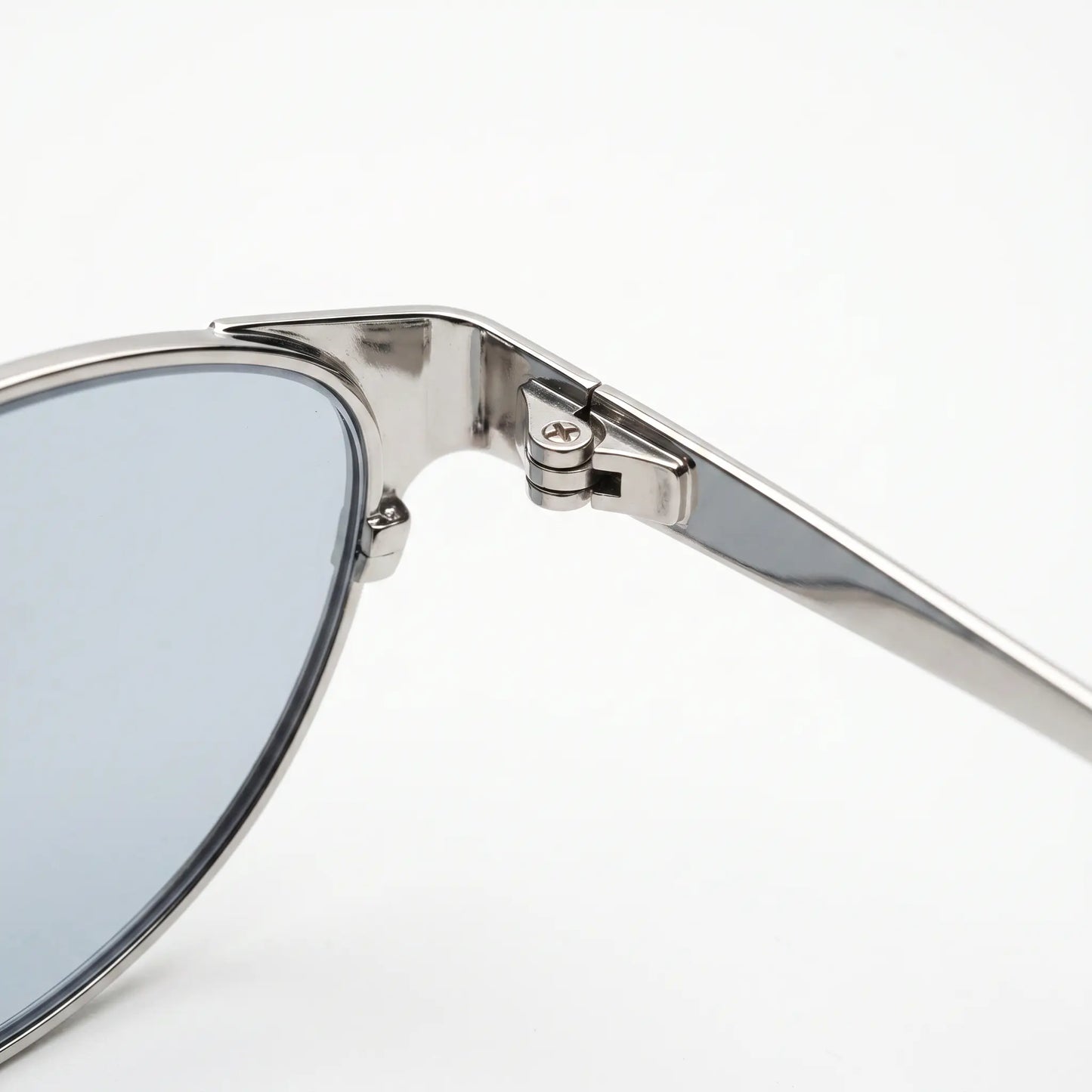 Kivago silver metal cat-eye sunglasses, showcasing the exquisite craftsmanship of the precision hinge mechanism and durable frame. A close-up view of the polished silver finish and light blue tinted lens.