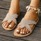 Desert Apricot Korvin bejeweled thong sandals adorned with clear crystal starfish embellishments, worn on feet with a shell and seahorse charm anklet, against a weathered wooden plank background.