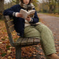 Kovara thermal quilted wide-leg trousers in olive green, worn by a woman sitting on a park bench reading in an autumn setting.
