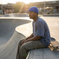 Kovari docker beanie fisherman hat in cobalt blue worn by a man at a skate park — side profile lifestyle view showing snug fit.