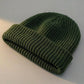 Kovari docker beanie fisherman hat in army green ribbed knit — three-quarter view showing rolled cuff and textured crown.