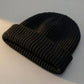 Kovari docker beanie fisherman hat in black ribbed knit — three-quarter view showing rolled cuff and structured crown.