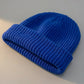 Kovari Docker Beanie fisherman hat in cobalt blue acrylic knit — three-quarter view showing vertical ribbed texture and thick rolled cuff.