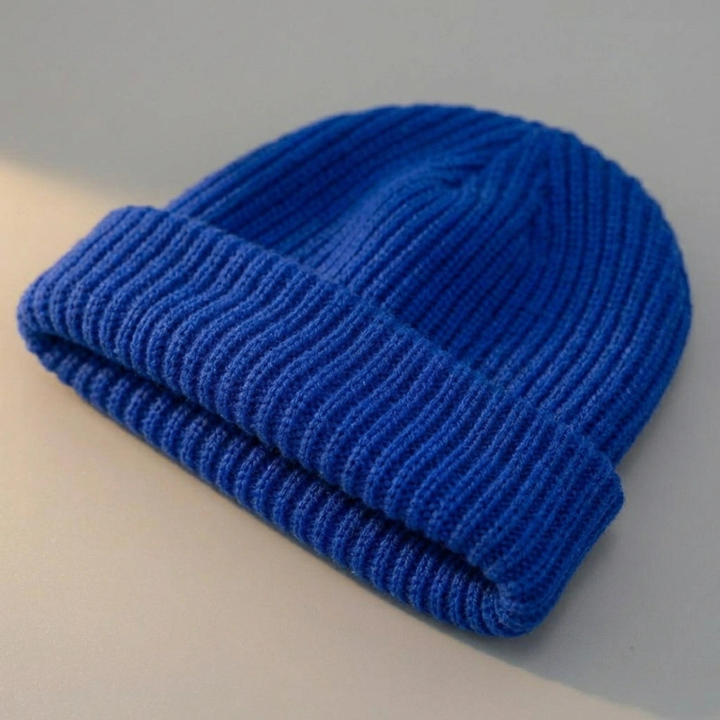 Kovari Docker Beanie fisherman hat in cobalt blue acrylic knit — three-quarter view showing vertical ribbed texture and thick rolled cuff.
