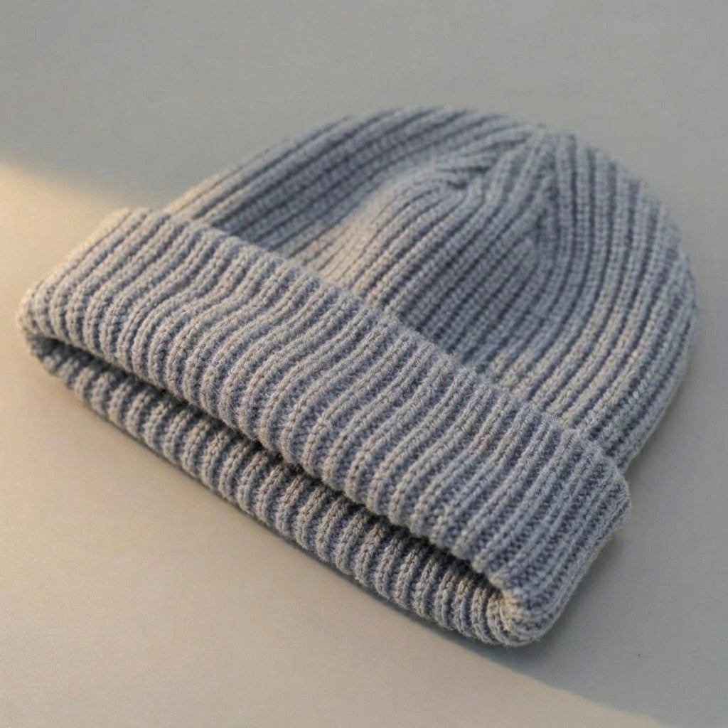 Kovari Docker Beanie fisherman hat in light grey ribbed knit, displayed flat showing the thick rolled cuff and soft texture.