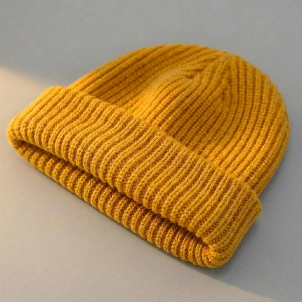 Kovari Docker Beanie fisherman hat in mustard yellow ribbed knit — three-quarter view showing the rolled cuff and structured crown.