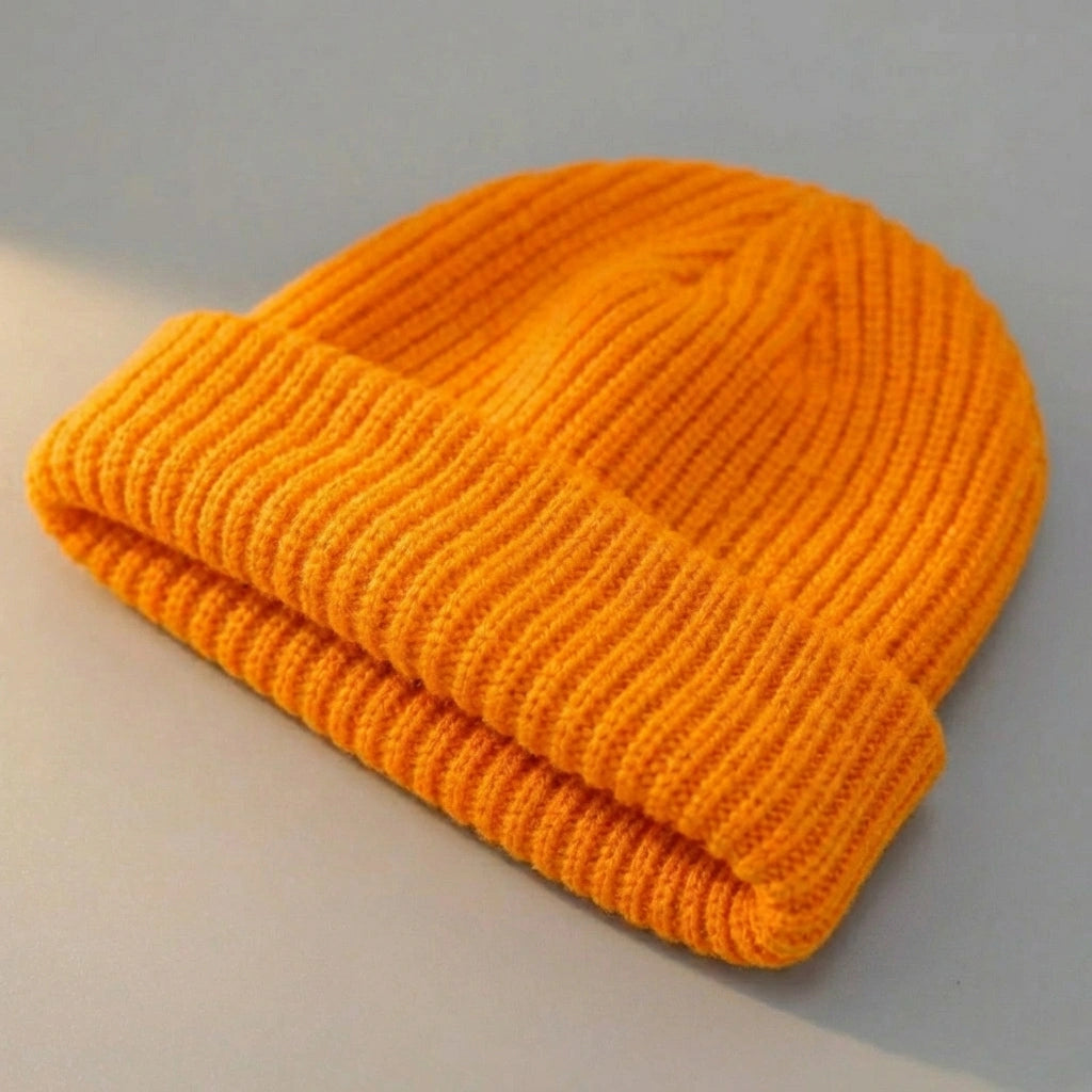 Kovari Docker Beanie fisherman hat in vibrant orange ribbed knit — three-quarter view showing the thick rolled cuff and structured crown.