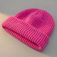 Kovari docker beanie fisherman hat in rose pink ribbed knit — high angle view showing rolled cuff and texture.