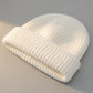 Kovari docker beanie fisherman hat in white ribbed knit — three-quarter view showing thick rolled cuff and soft texture.