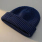 Kovari docker beanie fisherman hat in navy blue ribbed knit — three-quarter view showing thick rolled cuff and soft texture.