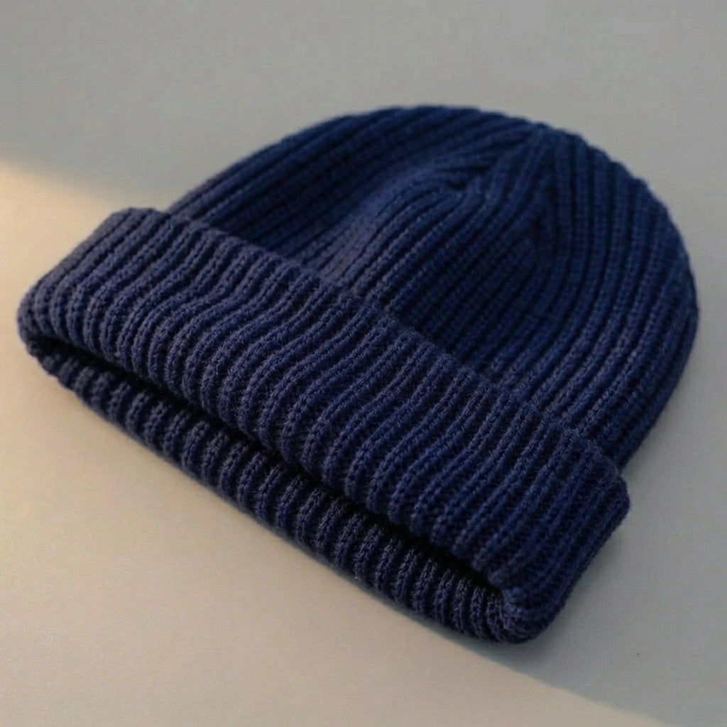 Kovari docker beanie fisherman hat in navy blue ribbed knit — three-quarter view showing thick rolled cuff and soft texture.