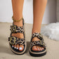 Women's Kovari leopard print platform slide sandals with double antique gold-tone buckles, worn on feet with white toenails and a gold anklet.